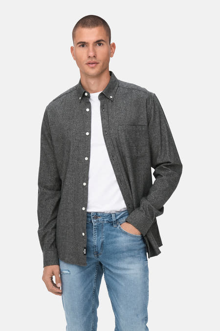 Chemise grise à manches longues de ONLY & SONS, portée sur un t-shirt blanc et des pantalons bleus de travail.