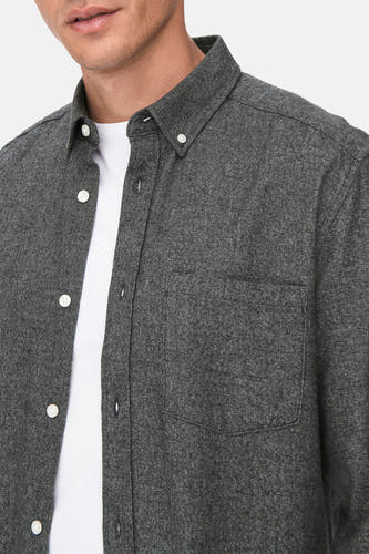Grijs overhemd met lange mouwen van ONLY & SONS®, met witte knopen en een borstzak, gedragen over een wit T-shirt.

