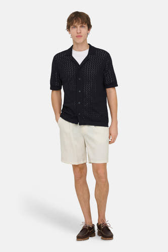 Ecru korte broek van ONLY & SONS, gecombineerd met een marineblauw openvallend overhemd en bruine schoenen.
