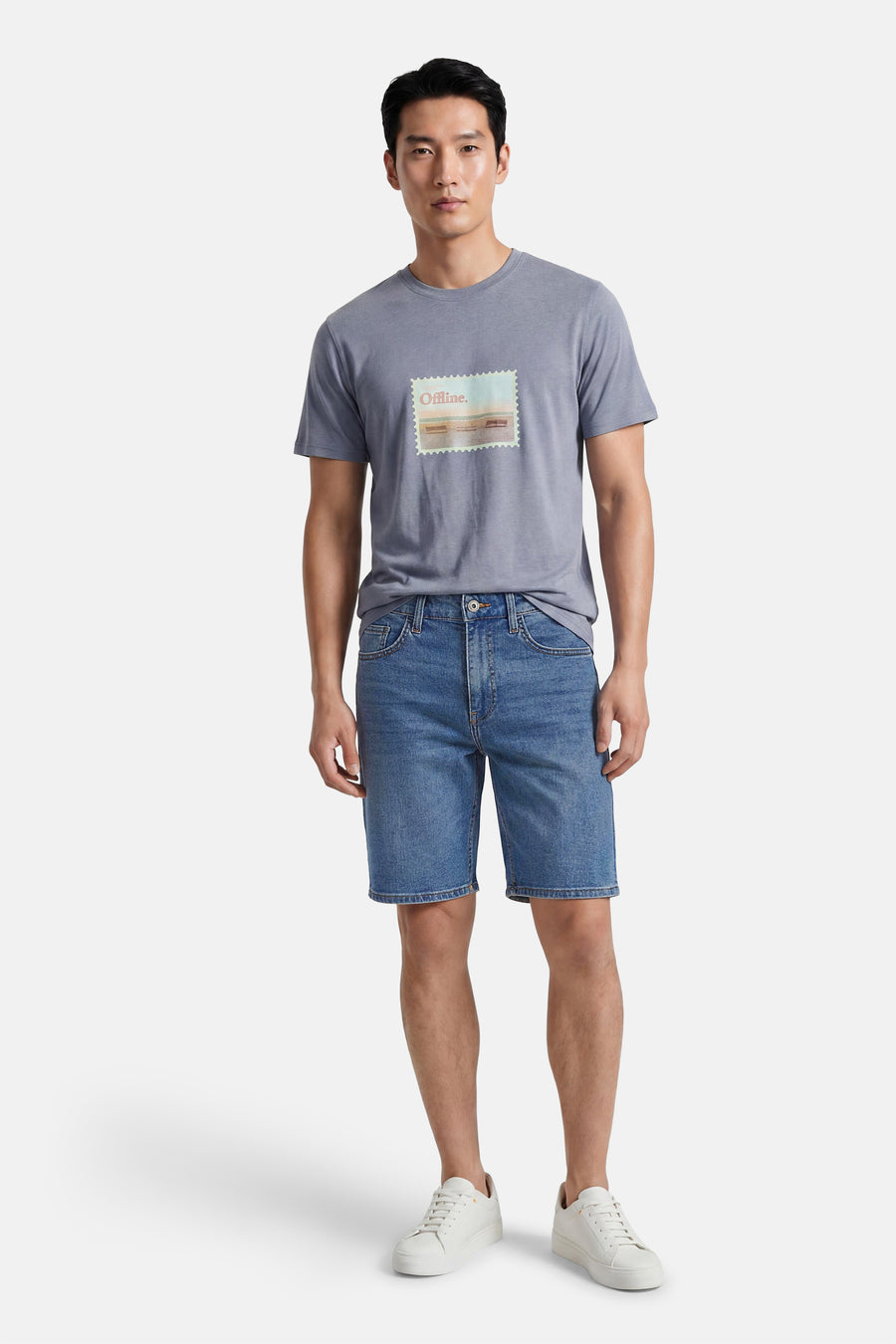 Mid-blauwe denim short van ONLY & SONS®, gedragen door een man met een grijs T-shirt en witte sneakers.