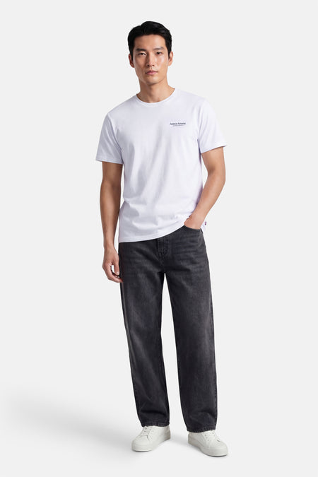 T-shirt blanc à manches courtes ONLY & SONS®, porté avec un jean noir et des baskets blanches.