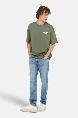 Groen T-shirt met korte mouwen van ONLY & SONS, met kleine print op de borst en gedragen met blauwe jeans.
