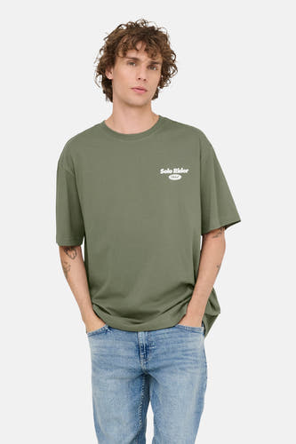 Groen T-shirt met korte mouwen van ONLY & SONS, met een kleine witte opdruk en gedragen met een blauwe jeans.
