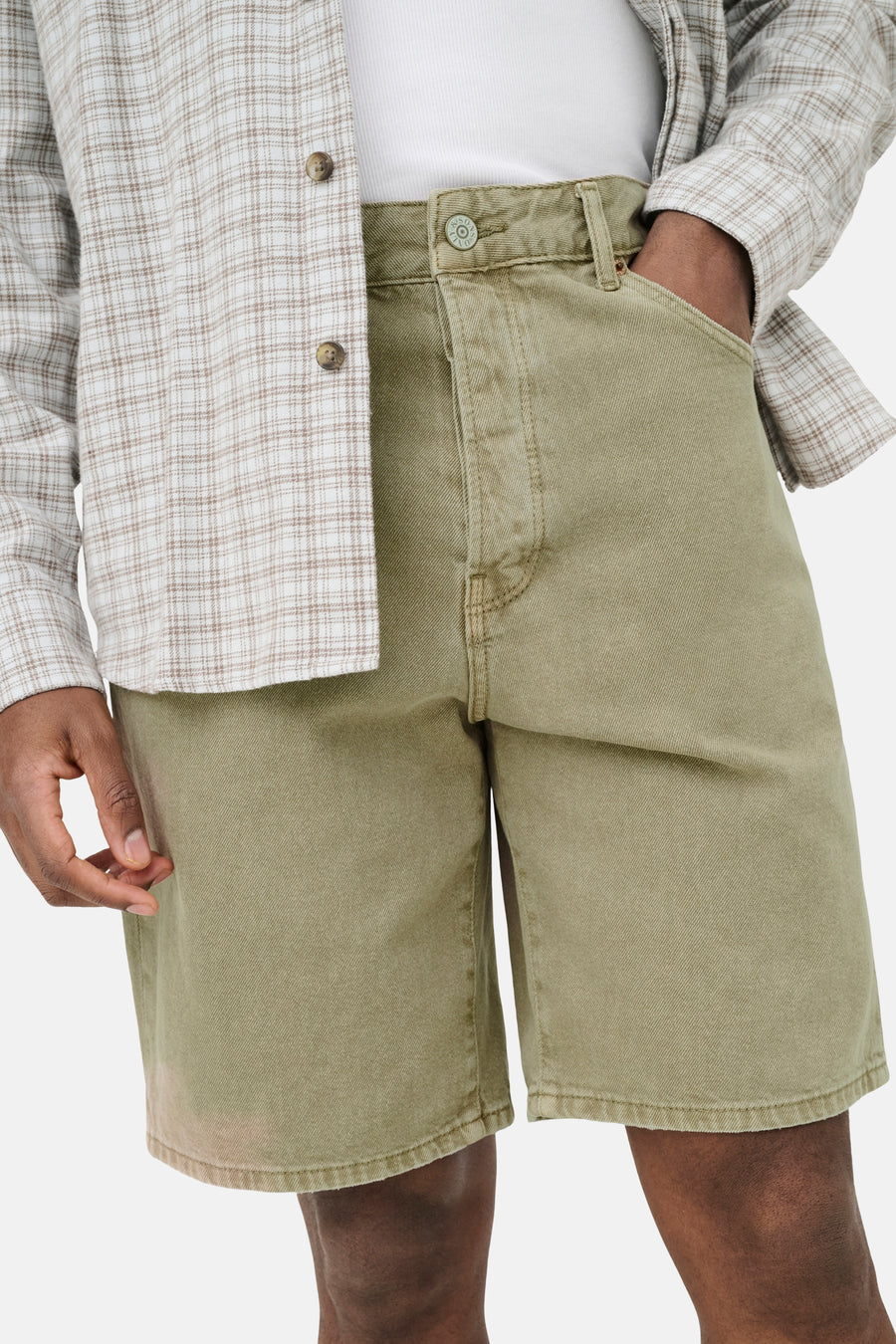 Beige jeansshort van ONLY & SONS met metalen knoop en lichte textuur, gedragen met geruit overhemd en wit T-shirt.