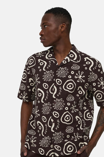 Bruin overhemd met korte mouwen van ONLY & SONS® met abstract wit patroon en reverskraag, gedragen door een man in zijprofiel.