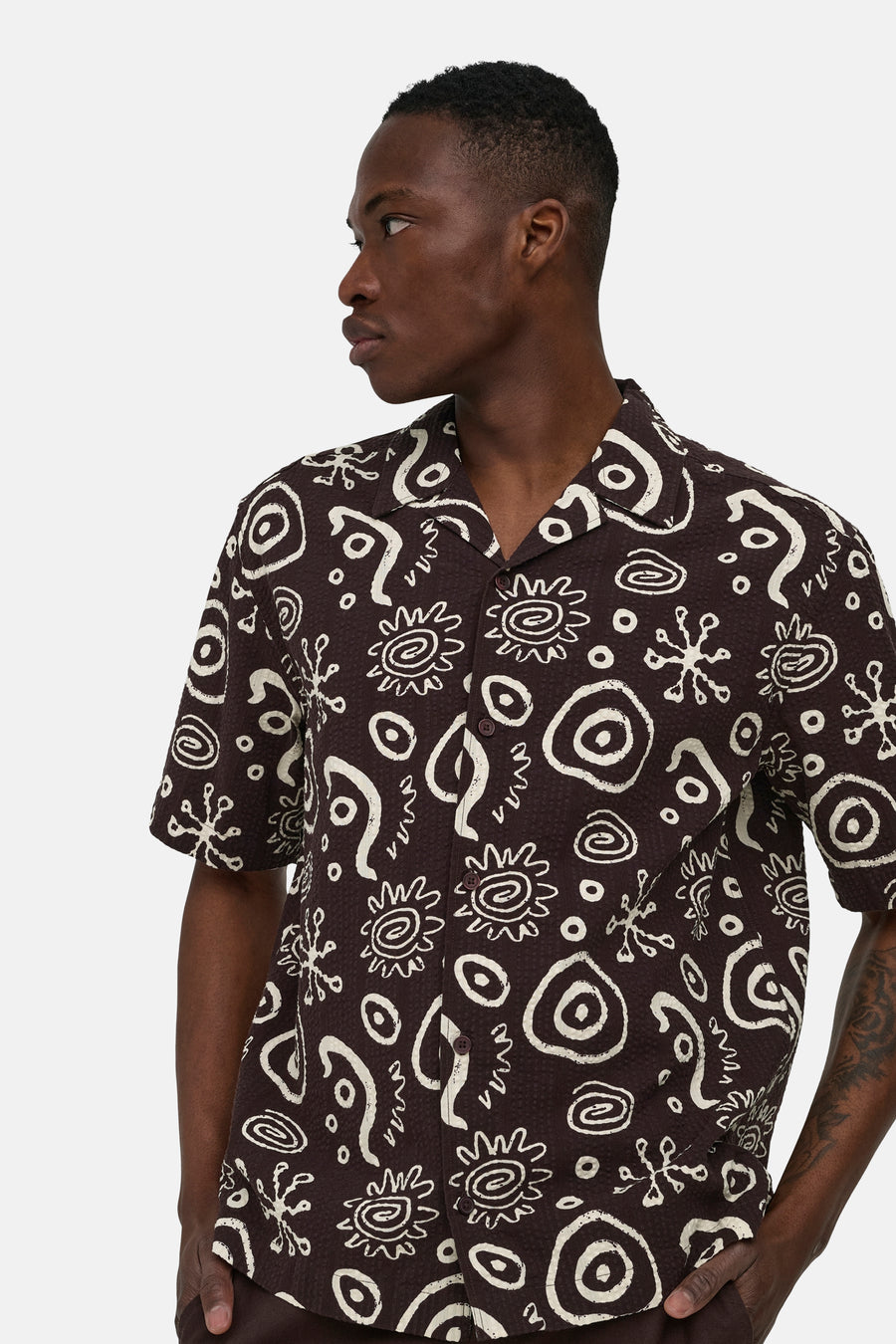 Bruin overhemd met korte mouwen van ONLY & SONS® met abstract wit patroon en reverskraag, gedragen door een man in zijprofiel.