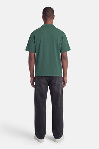 Polo verte ONLY & SONS® de couleur verte avec col, manches courtes et tissu texturé, dos, portée avec un jean foncé et des baskets blanches.