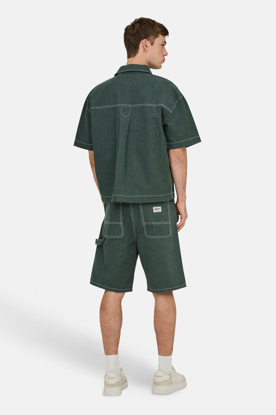 Groen overhemd met korte mouwen van ONLY & SONS® met wit contraststiksel en wijde pasvorm, van achteren gezien, gedragen met bijpassende shorts.