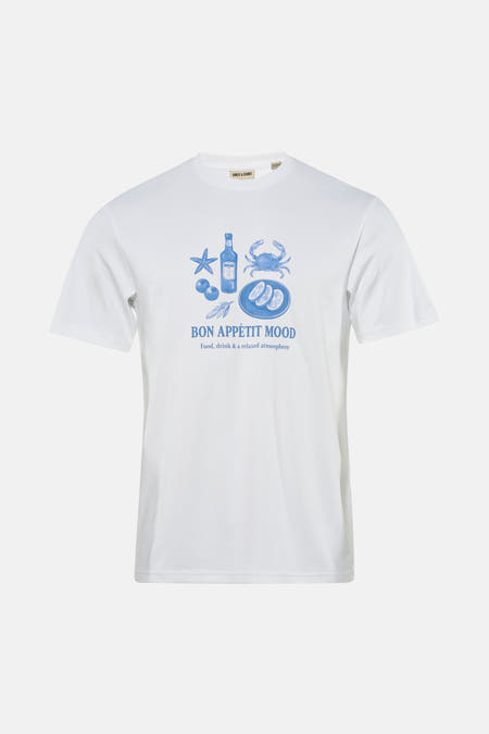 T-shirt blanc à manches courtes ONLY & SONS® avec imprimés bleus, porté avec un jean déchiré et des baskets.