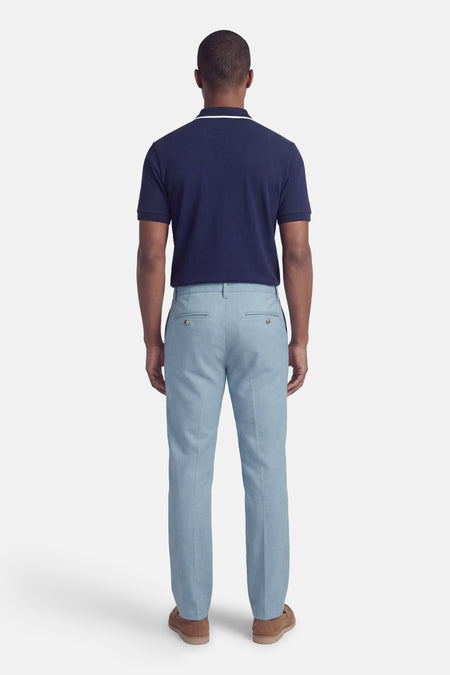 Blauwe broek van ONLY & SONS®, met achterzakken en een effen dessin, gecombineerd met een marineblauw poloshirt en bruine schoenen.