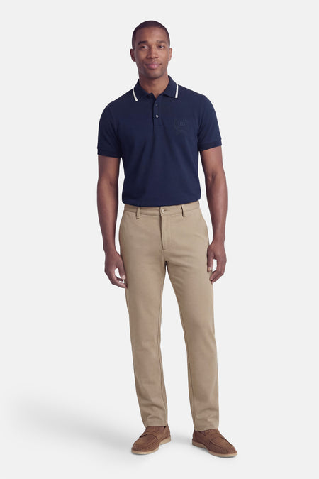 Beige broek van ONLY & SONS, met subtiele textuur en gecombineerd met een marineblauwe polo en bruine schoenen.