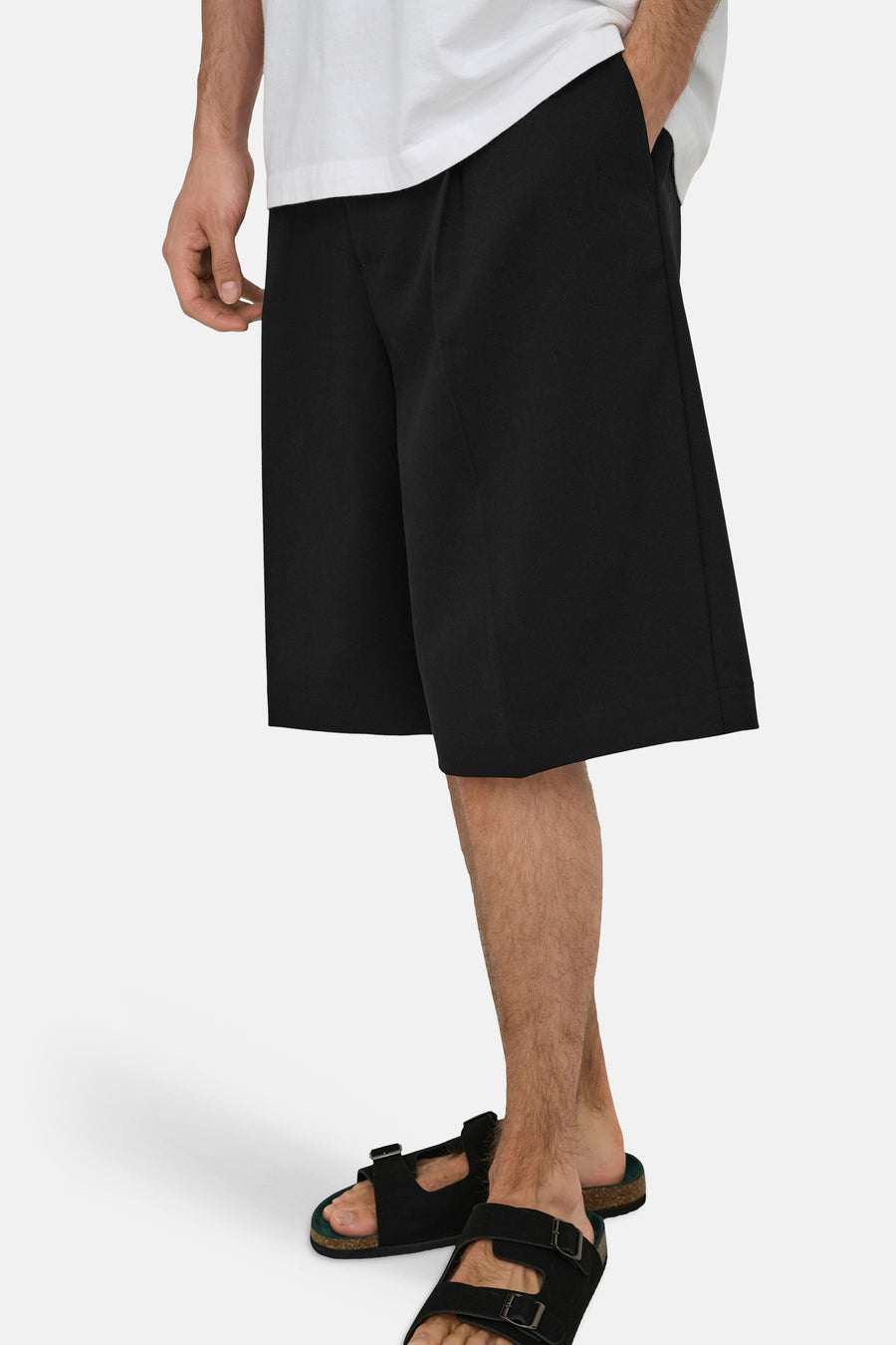 Zwarte korte broek van ONLY & SONS® met rechte pasvorm, gedragen met wit overhemd en zwarte sandalen, zijprofiel.