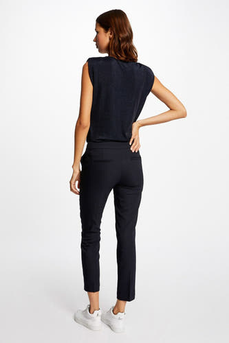 Pantalon de costume noir de Morgan De Toi, vu de par derrière, combiné avec un haut sans manches et des baskets blanches.