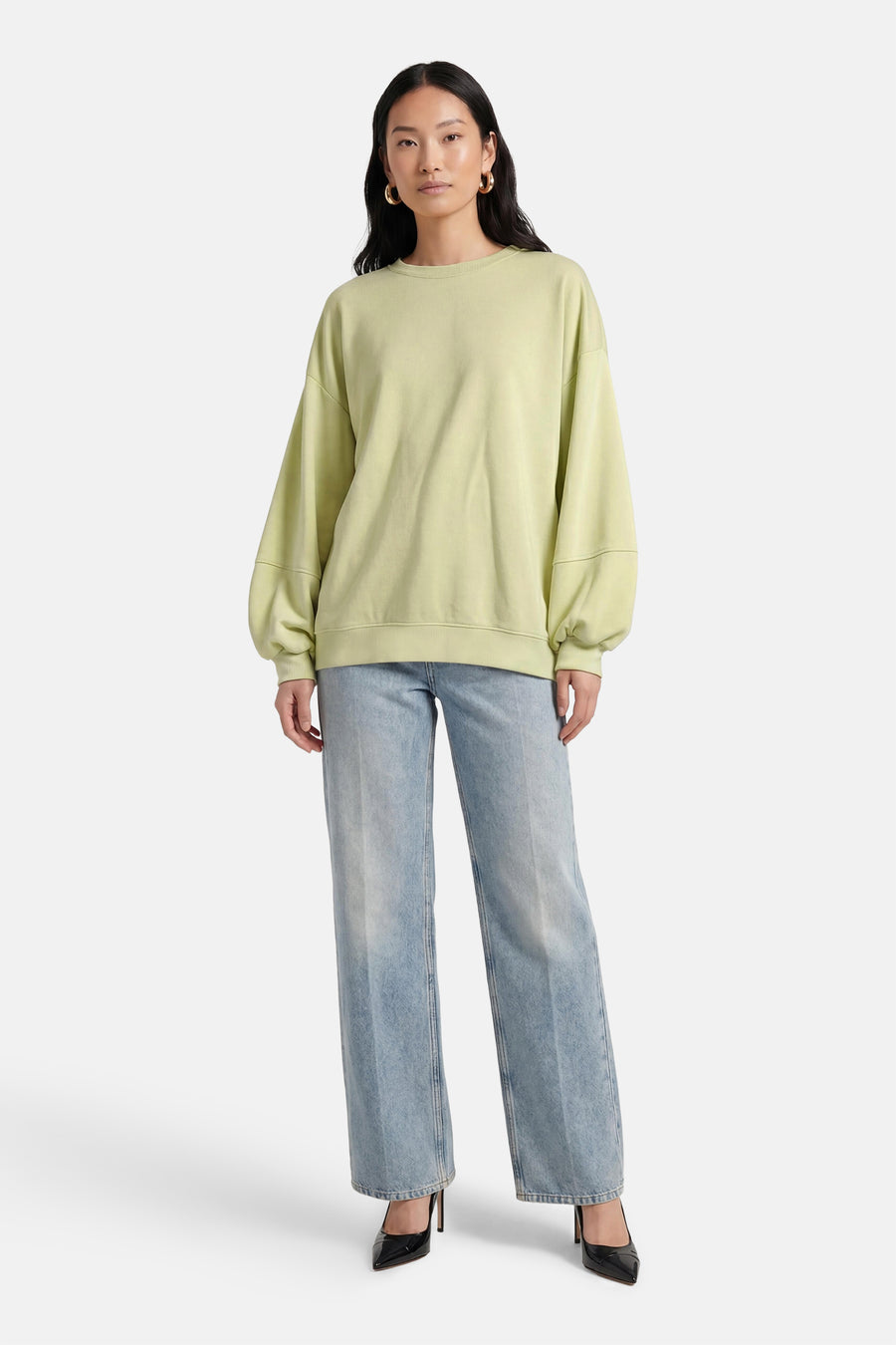 Groene sweater van Terra di Siena, met lange mouwen en gecombineerd met wijde jeans en zwarte pumps.
