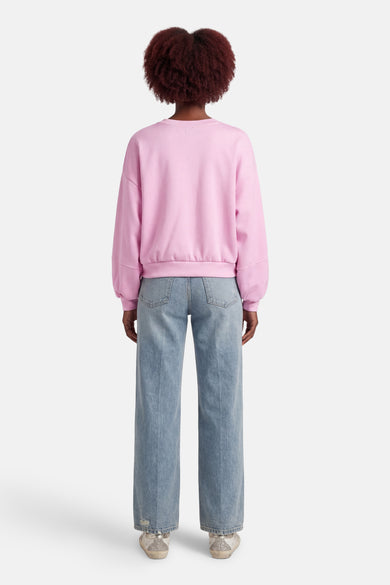 Pull rose à col rond de Terra di Siena, combiné avec un jean bleu.