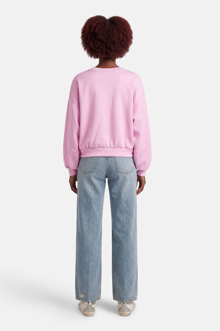 Pull rose à col rond de Terra di Siena, combiné avec un jean bleu.