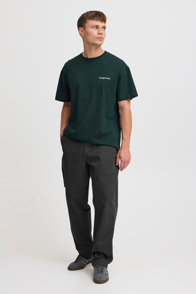 Grijze broek van THEJOGGCONCEPT, gecombineerd met een donkergroen T-shirt en grijze sneakers.