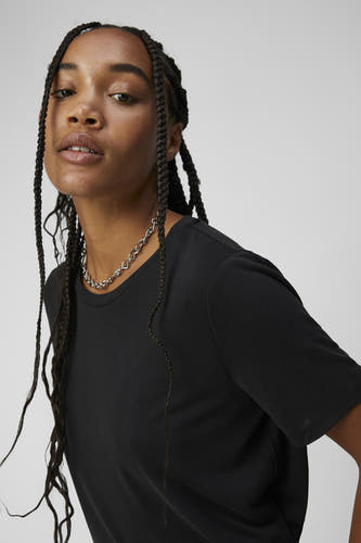 Zwart T-shirt van OBJECT, gedragen met een zilveren ketting, close-up.
