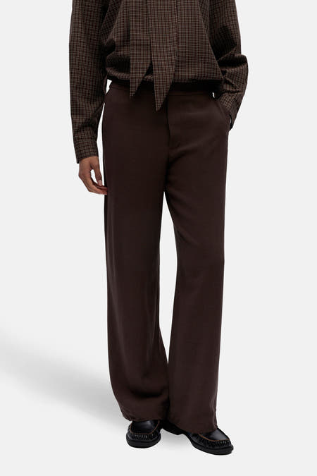 Bruine broek van OBJECT, met wijde pijpen en gecombineerd met een geruit overhemd met strik.
