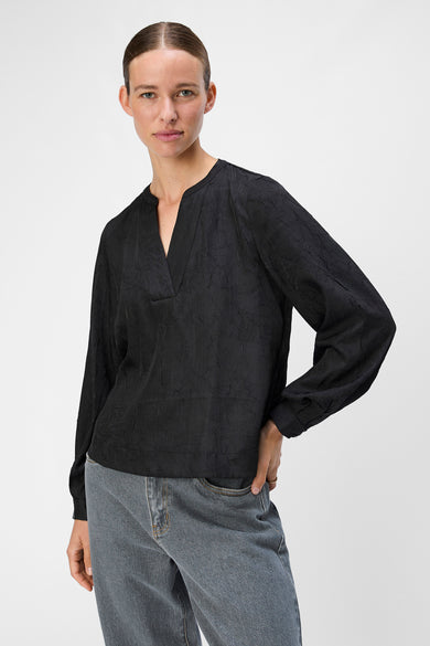 Zwarte blouse met lange mouwen van OBJECT, met een subtiele textuur en gedragen met een blauwe jeans.
