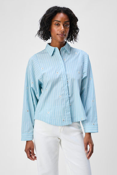 Blauw gestreept overhemd met lange mouwen van OBJECT, afgewerkt met decoratieve elementen, gedragen met een witte broek.

