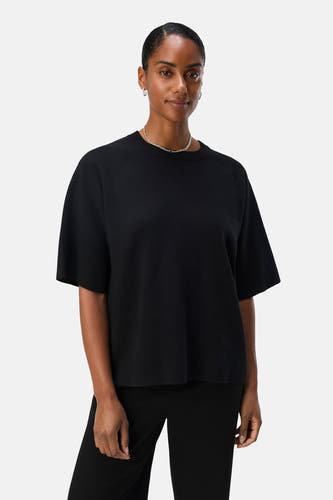 Pull noir de OBJECT, à manches courtes et porté avec une chaîne argentée et un pantalon noir.