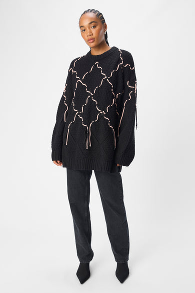 Pull-over noir avec col rond d'OBJECT, avec des points décoratifs roses et des manches longues, porté avec un pantalon noir.