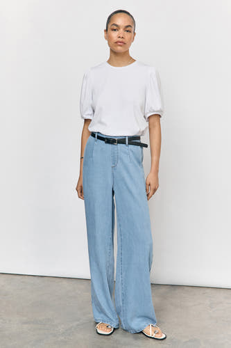 Lichtblauwe denim broek van OBJECT, gecombineerd met een zwarte riem en witte sandalen.