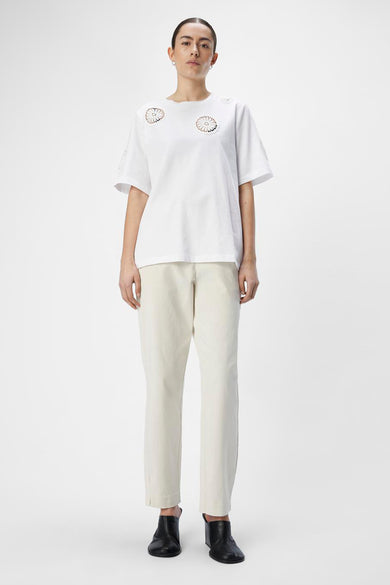 Wit T-shirt met korte mouwen van OBJECT, met gehaakte bloemmotieven op de schouders, gecombineerd met een beige broek en zwarte schoenen.