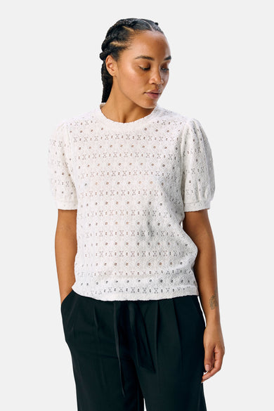Wit T-shirt met korte mouwen van OBJECT, met een gebloemd patroon en gedragen met een zwarte pantalon.
