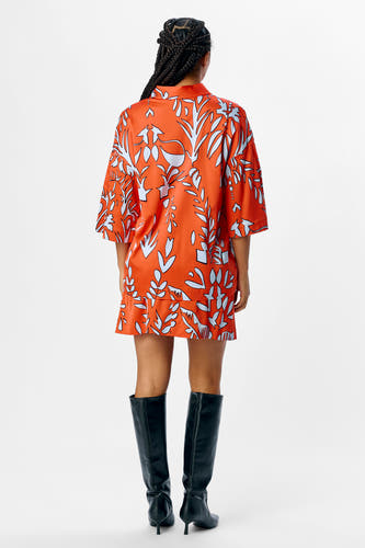 Oranje hemd met korte mouwen van OBJECT, met een bladmotief en gedragen met zwarte laarzen.
