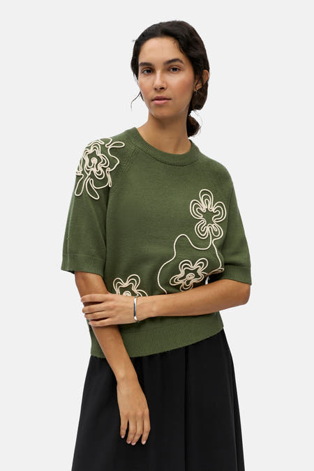 Groene trui met ronde hals van OBJECT, met witte bloemmotieven en korte mouwen, lifestyle shot van voorzijde