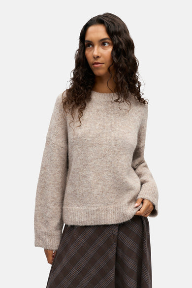 Ecru trui met ronde hals van OBJECT, gecombineerd met bruine geruite broek.
