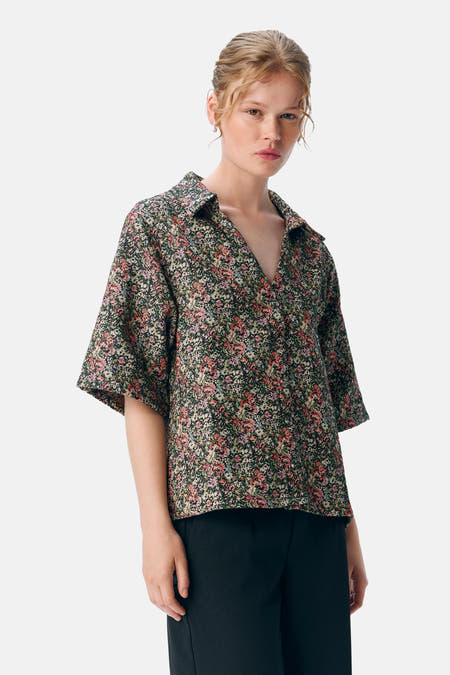 Chemise multicolore d'OBJECT avec imprimé de fleurs, portée avec un pantalon noir.