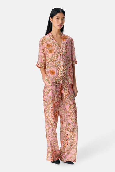 Chemise rose à manches courtes d'OBJECT, avec un motif de fleurs frappant et portée avec une pantalon coordonné.