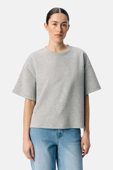 Grijze sweater van OBJECT, met korte mouwen en gedragen met een blauwe jeans.
