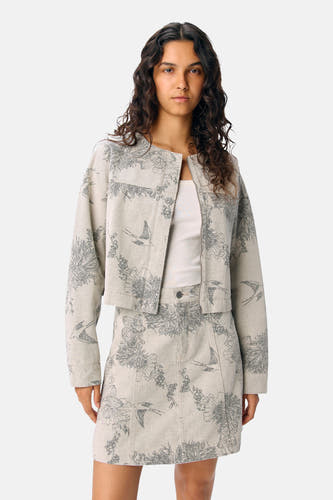 Robe courte écru d'OBJECT, avec un motif de fleurs et d'oiseaux détaillé, combinée à une chemise blanche et un manteau coordonné.