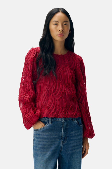 Blouse rouge à longues manches d'OBJECT, avec une texture décorative et associée à un jean bleu.