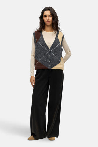 Grijs gilet van OBJECT, met een argyle ruitpatroon, gedragen over een beige shirt en wijde zwarte broek.
