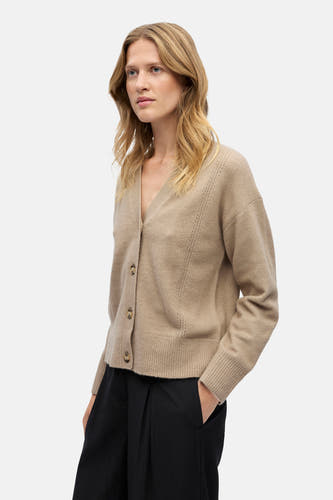 Beige gilet van OBJECT, met knoopsluiting, gedragen over een zwarte broek met wijde pijpen.
