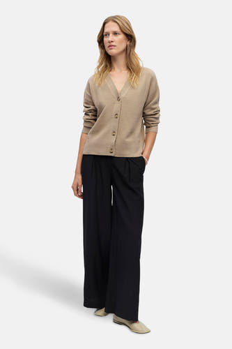 Beige gilet van OBJECT, met knoopsluiting, gecombineerd met zwarte pantalon en crèmekleurige schoenen.
