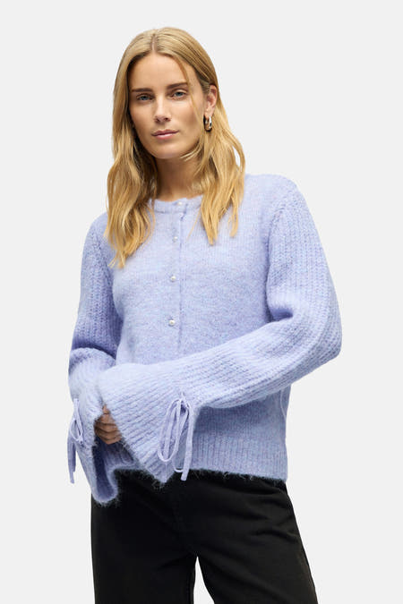 Gilet parme d'OBJECT, avec des manches longues à rayures et des boutons en nacre, porté avec un pantalon noir.