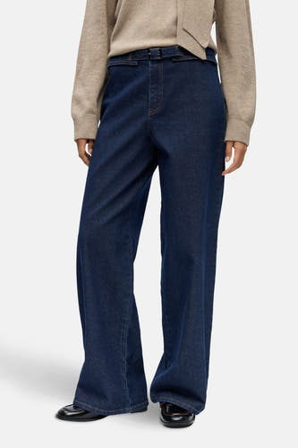 Jean bleu marine, large d'OBJECT, avec une ceinture et un pull beige à col montant.