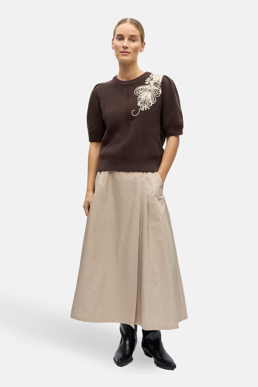 Bruine trui van OBJECT met korte mouwen en een decoratieve bloemapplicatie, gecombineerd met een lange, beige rok en zwarte laarzen.
