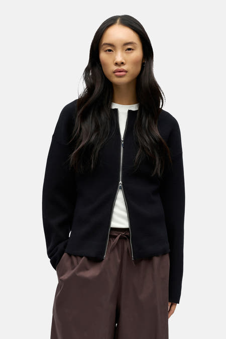 Zwart gilet van OBJECT, met een zilverkleurige ritssluiting en bruine broek met trekkoord.
