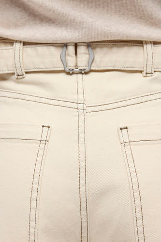 Beige jeans met speciale pasvorm van OBJECT, met donkere stiksels, zilverkleurige gesp aan de achterkant en gedragen met een lichtgebreide top.