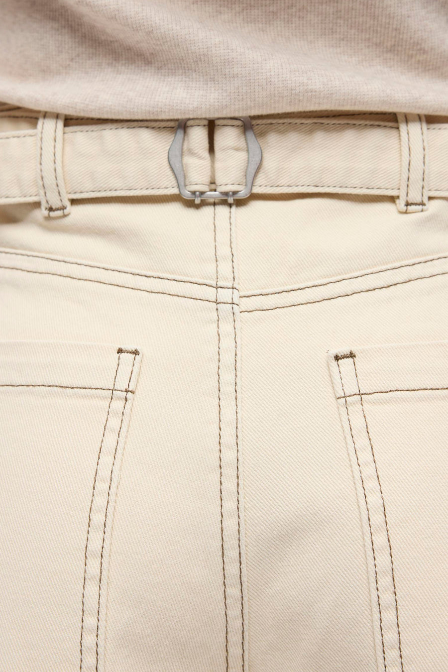 Beige jeans met speciale pasvorm van OBJECT, met donkere stiksels, zilverkleurige gesp aan de achterkant en gedragen met een lichtgebreide top.