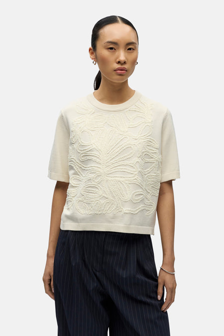 Pull de couleur écru à col rond de OBJECT, avec motif floral décoratif sur le devant, porté avec un pantalon rayé.