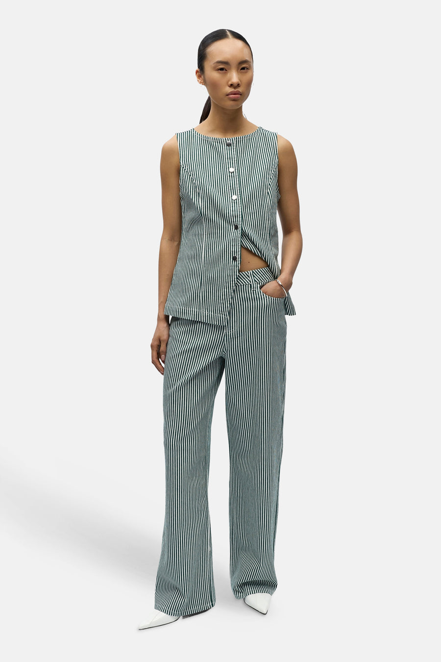 Pantalon de saison vert 5 poches de OBJECT, à rayures verticales et associé à un haut rayé et des chaussures blanches.