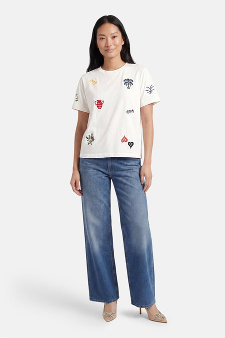 T-shirt multicolore d'OBJECT avec broderies d'un pot, de cœurs et de plantes, porté par un mannequin avec un jean.